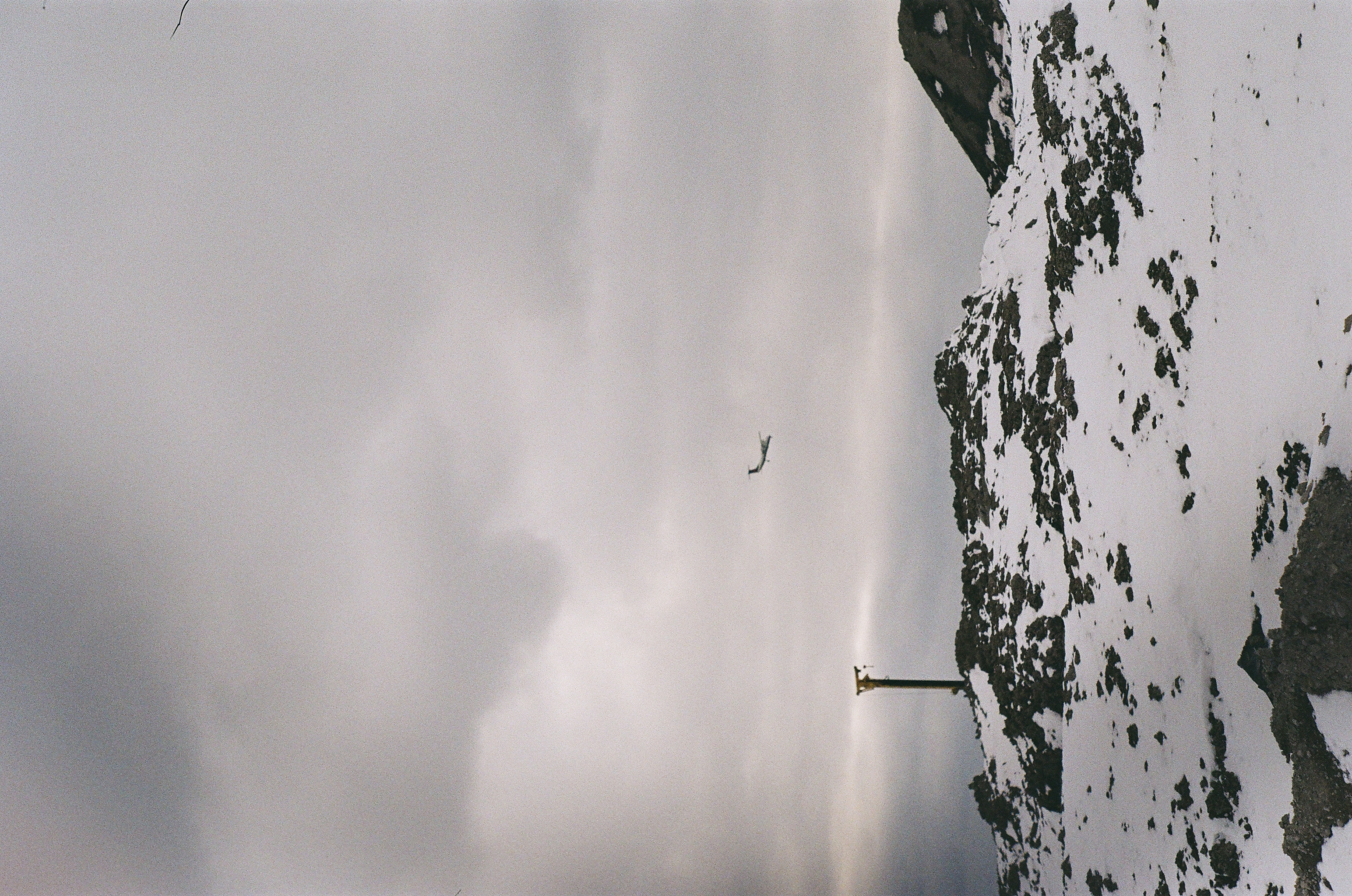 Plane flying over piles of snow-covered dirt