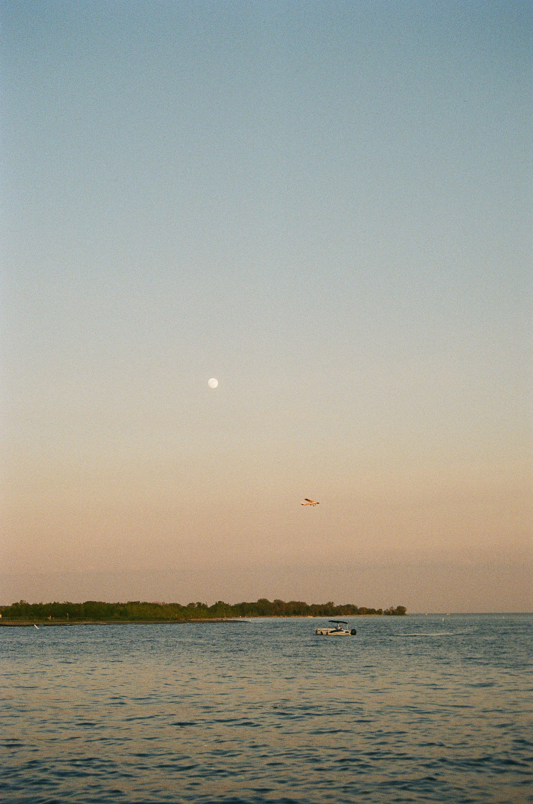 A plane taking off from Billy Bishop Airport with a boat in the foreground